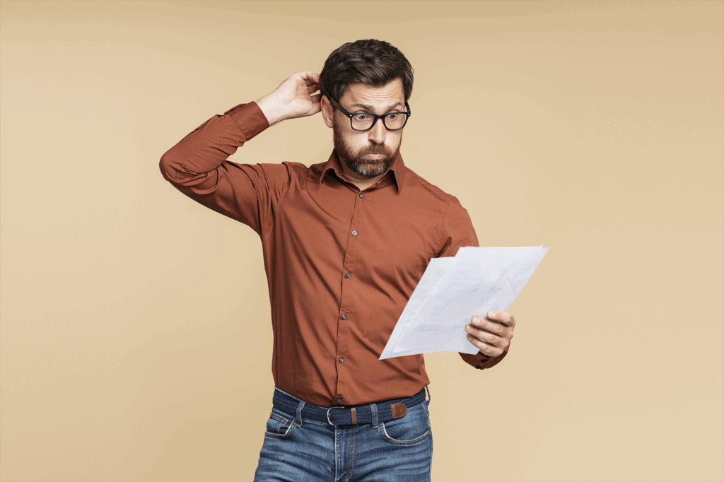 Estudante de meia-idade confuso, homem de óculos, segurando documentos, lendo informações.