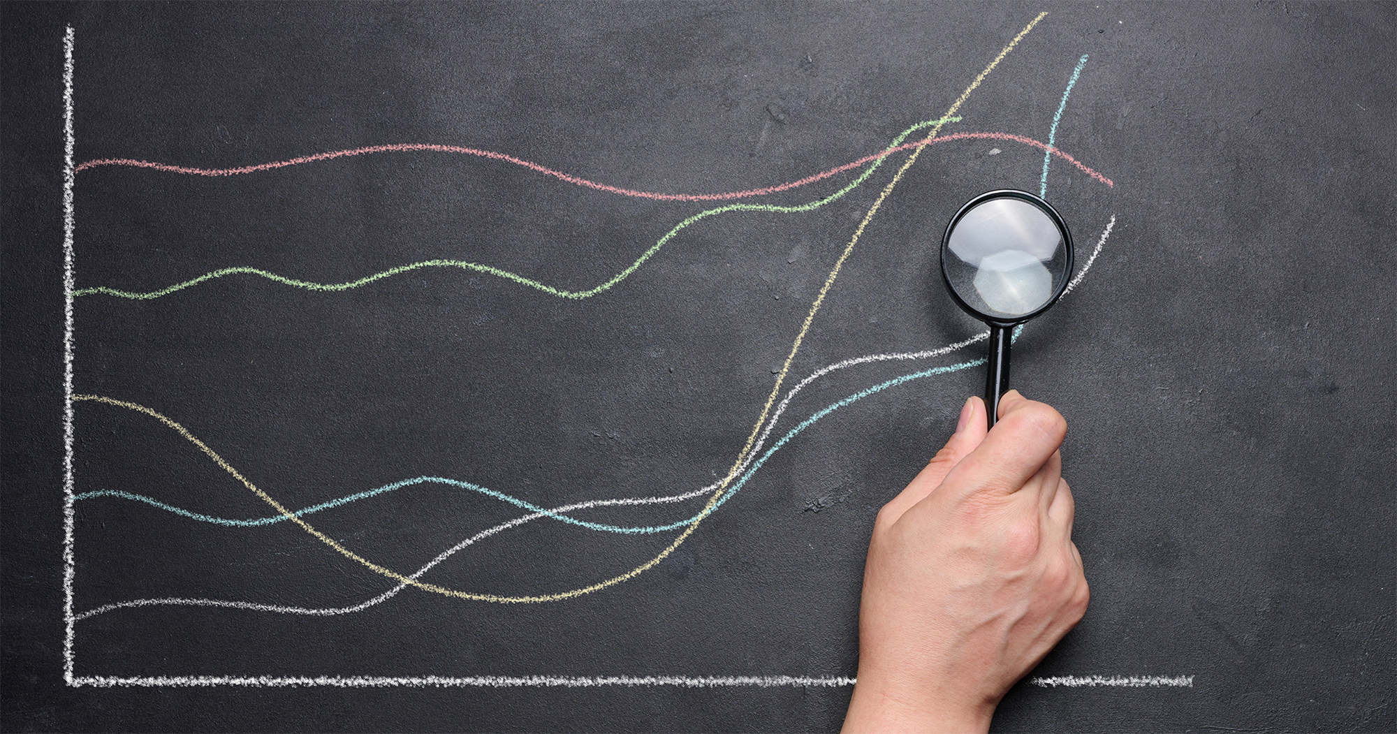 A mão de uma mulher aponta para um gráfico com indicadores crescentes desenhados