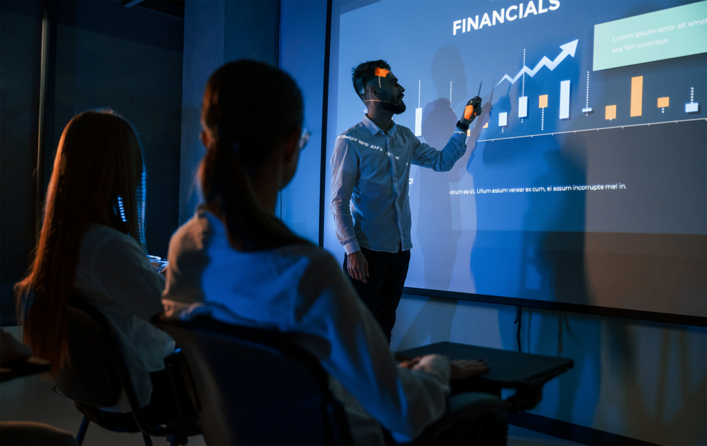 Líder masculino conversando com funcionários mostrando o plano no projetor no escritório